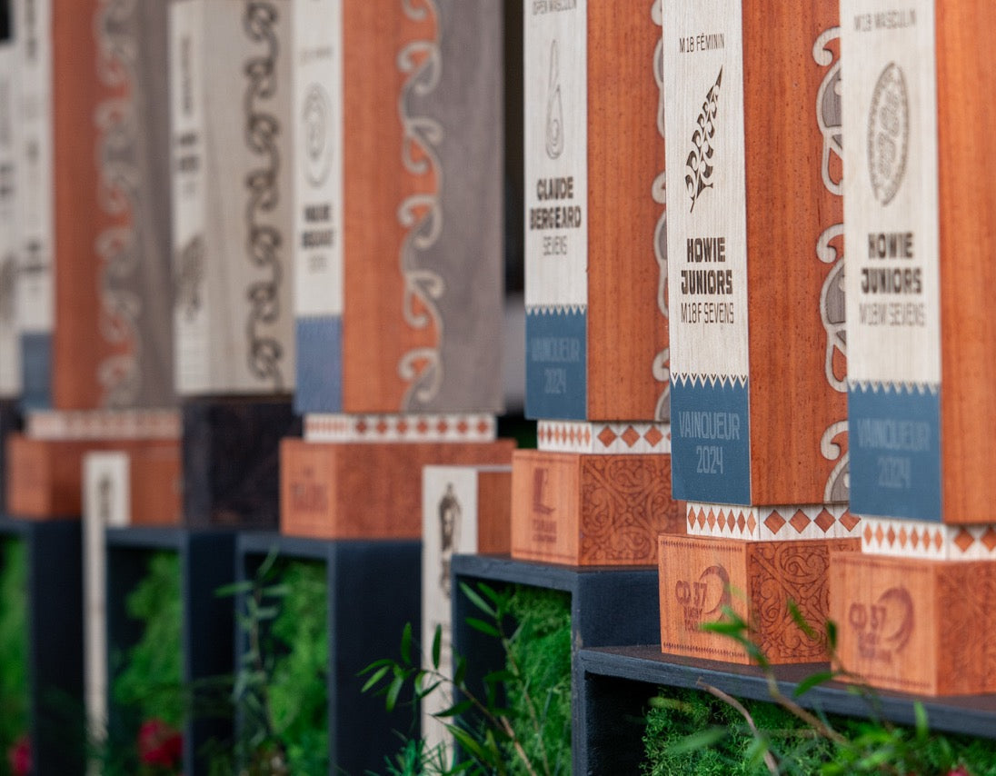 Trophées en bois personnalisés Vulka alignés photographiés sur des carrés avec de l'herbe verte